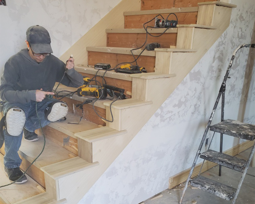 female contractor building new wooden stairs at house interiors del city ok