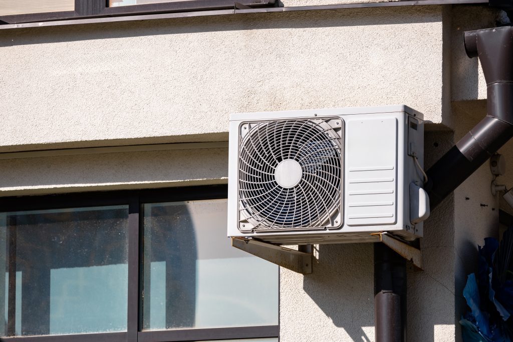 a white air conditioner mounted on the side of a building photo